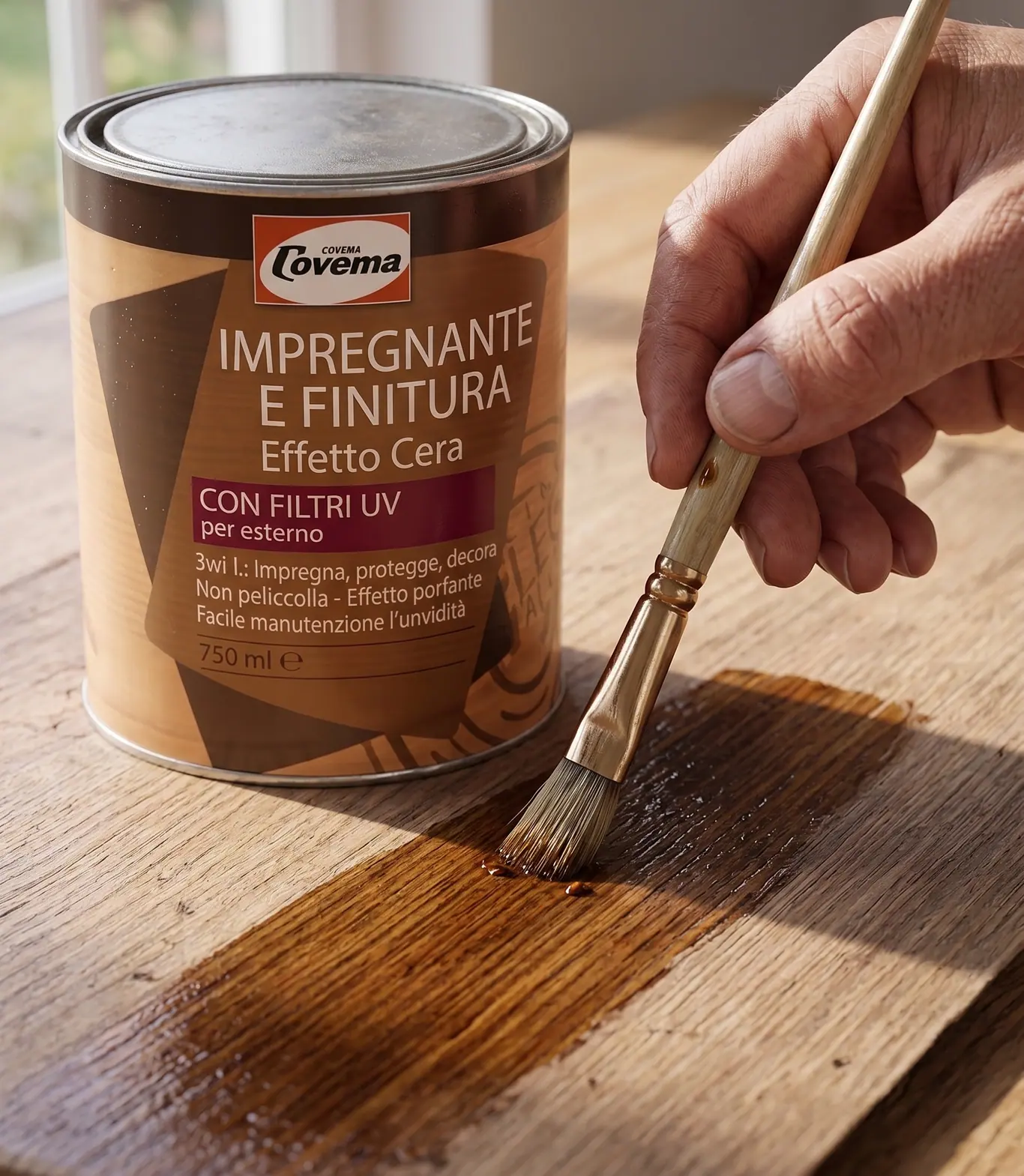A lata do Impregnante e Finitura Effetto Cera com filtros UV, ao lado de uma mão que aplica o produto a pincel sobre uma tábua