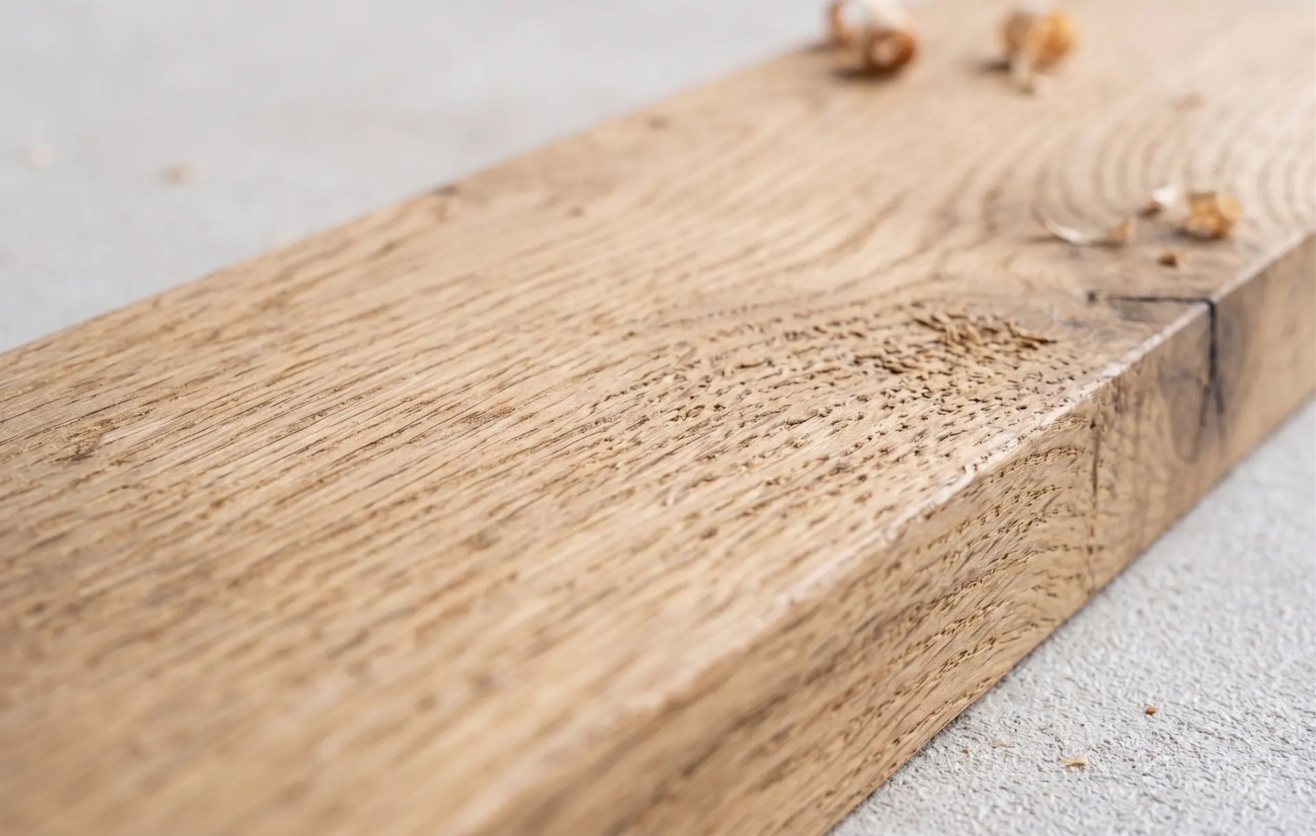 Échantillon de poutre en bois clair, photographié de biais sur fond neutre
