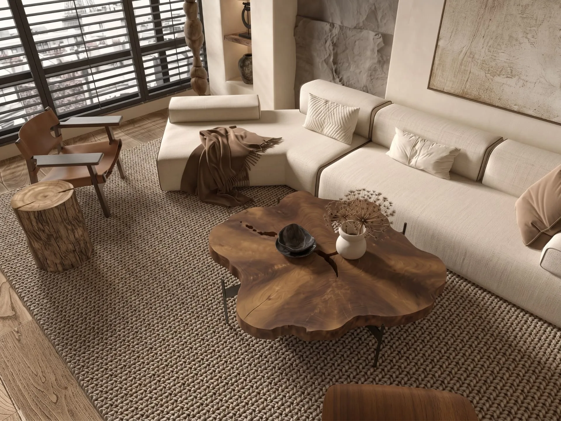 Salon avec canapé crème, fauteuil en cuir et table basse en bois massif au veinage vivant, sur un tapis en fibres naturelles tressées