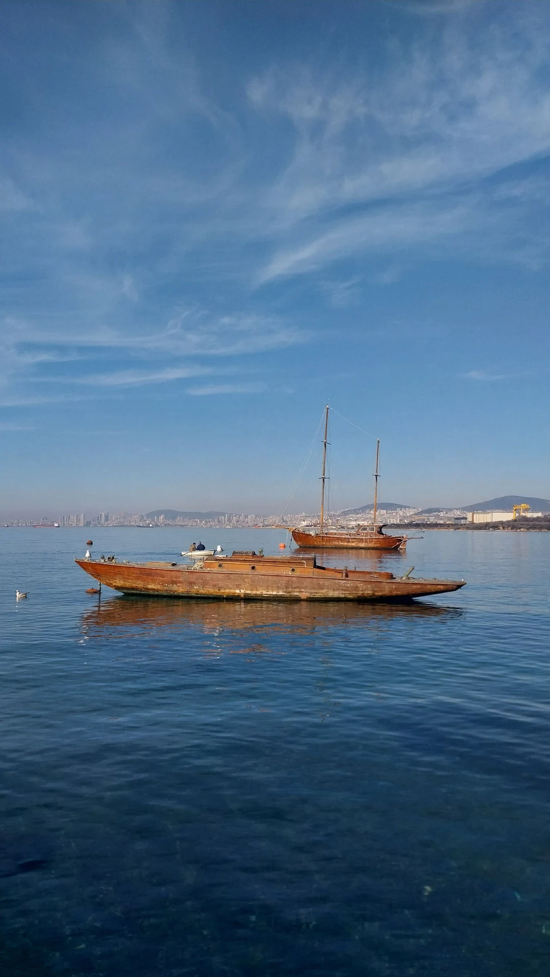 Holzboote vor Anker in einer Bucht an einem klaren Tag