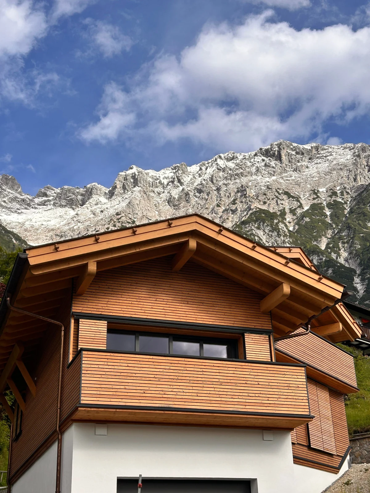Holzverkleidetes Haus am Fuß der Berge